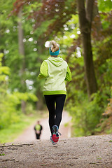 Image showing Sporty young female runner in the forest.