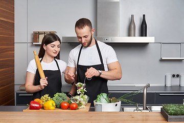 Image showing Young family in the kitchen with vegetables