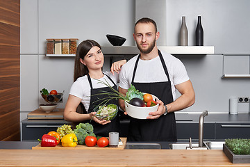 Image showing Young family in the kitchen with vegetables