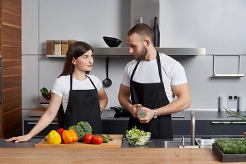 Image showing Young family in the kitchen with vegetables
