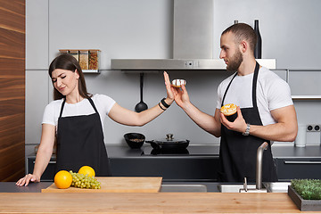 Image showing Young family in the kitchen with vegetables