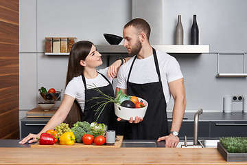 Image showing Young family in the kitchen with vegetables