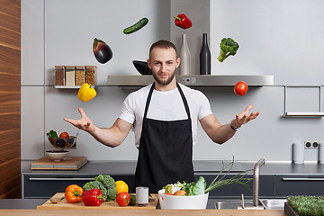 Image showing man in the kitchen juggling with vegetables