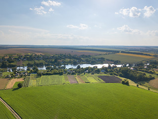 Image showing Amazing countryscape with green fields, river, greenery and blue cloudy sky in a summer time.