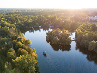 Image showing Beautiful countryside landscape picturesque river with ships, green forest with summer sky at sunset. Aerial view from drone at Sofiyivsky park, city Uman, Ukraine