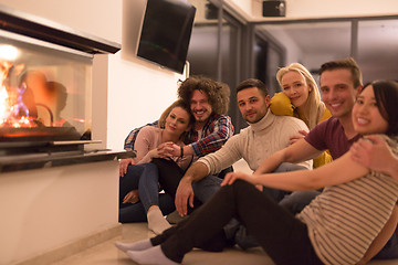 Image showing multiethnic couples sitting in front of fireplace