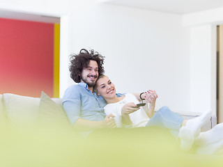 Image showing Young couple on the sofa watching television