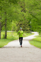 Image showing Sporty young female runner in city park..