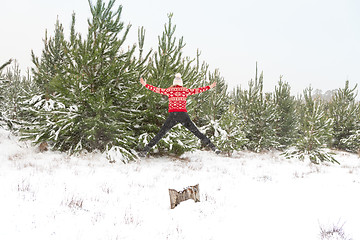 Image showing Leap into Life  Woman jumping high in a snowy landscape