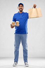 Image showing happy indian delivery man with food and drinks