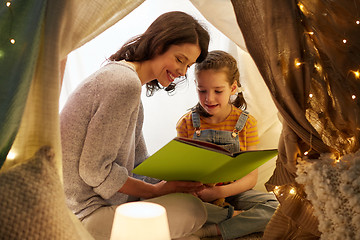 Image showing happy family reading book in kids tent at home