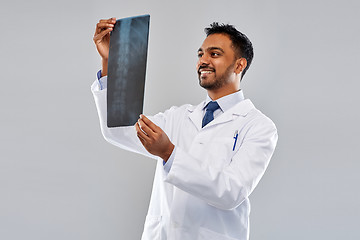 Image showing smiling indian doctor looking at spine x-ray