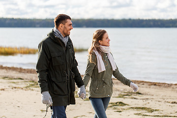 Image showing couple walking along autumn beach