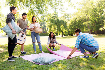 Image showing friends arranging place for picnic at summer park