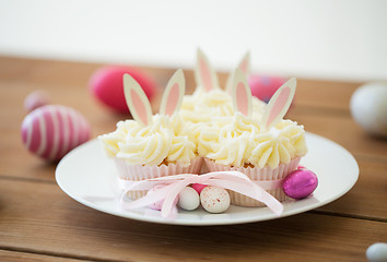 Image showing cupcakes with easter eggs and candies on table