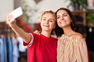 Image showing female friends taking selfie at clothing store