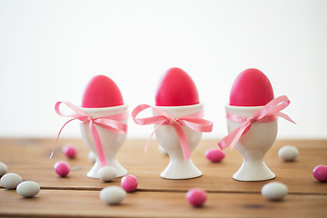 Image showing easter eggs in holders and candy drops on table