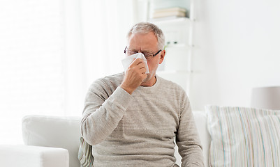 Image showing sick senior man with paper wipe blowing his nose