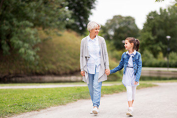 Image showing grandmother and granddaughter walking at park