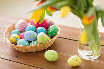 Image showing colored easter eggs in basket and flowers at home