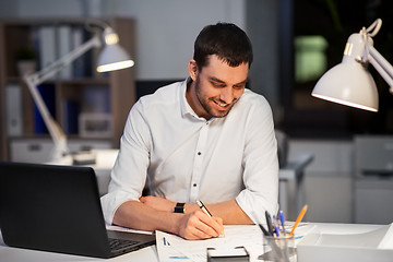 Image showing businessman with papers working at night office