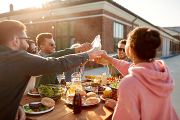 Image showing happy friends toasting drinks at rooftop party