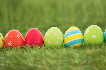 Image showing row of colored easter eggs on artificial grass