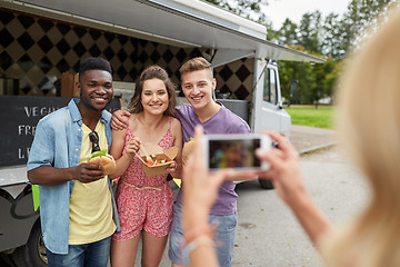 Image showing woman photographing friends eating at food truck