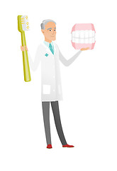 Image showing Dentist with dental jaw model and toothbrush.