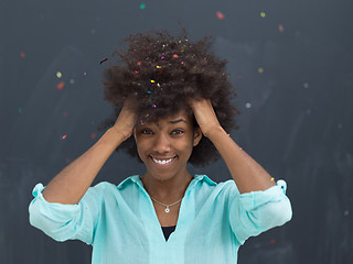 Image showing black woman blowing confetti in the air