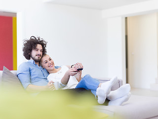 Image showing Young couple on the sofa watching television