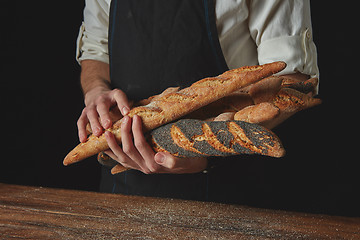 Image showing Men\'s hands hold baguettes