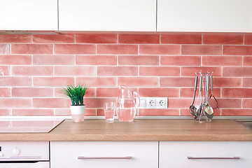 Image showing Modern kitchen at home with kitchenware and flowerpot on a top and wall tiles in a trend color of the year 2019 Living Coral Pantone.