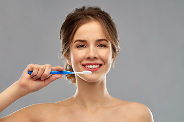 Image showing smiling woman with toothbrush cleaning teeth