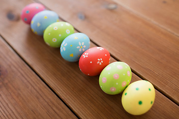 Image showing row of colored easter eggs on wooden table