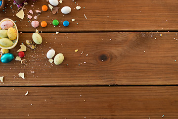 Image showing chocolate eggs and candy drops on wooden table