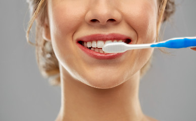 Image showing close up of woman with toothbrush cleaning teeth