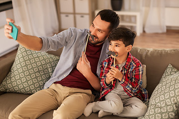 Image showing father and son taking selfie at home