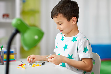 Image showing little boy playing with building kit at home