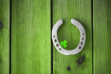 Image showing horseshoe with shamrock on green wood boards