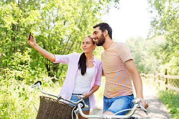 Image showing couple with bicycles taking selfie by smartphone