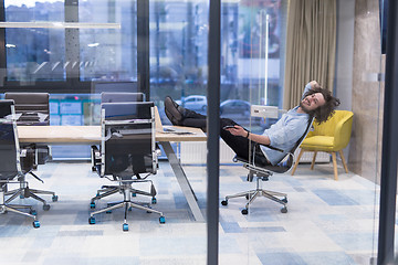 Image showing young businessman relaxing at the desk