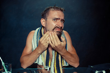 Image showing Close up photo of young man looking for acnes on his face