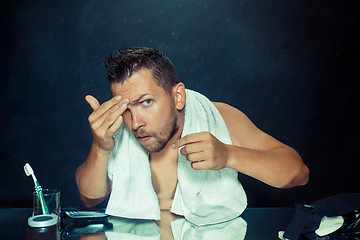 Image showing Close up photo of young man looking for acnes on his face