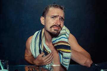 Image showing Close up photo of young man looking for acnes on his face