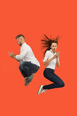 Image showing Full length of young couple with mobile phone while jumping