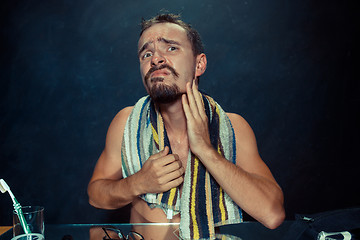 Image showing Close up photo of young man looking for acnes on his face