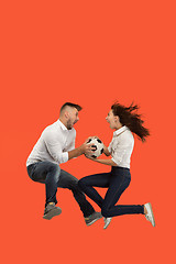 Image showing The young man and woman as soccer football players kicking the ball at studio