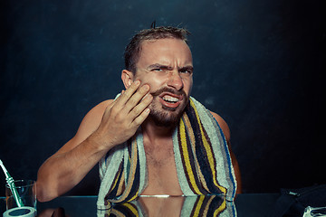 Image showing Close up photo of young man looking for acnes on his face