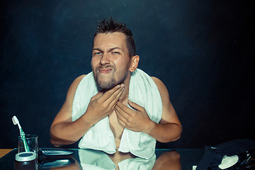 Image showing Close up photo of young man looking for acnes on his face